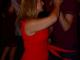 2 people dancing to salsa music. One in a red dress